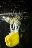 Fototapeta  - Yellow bell peppers were thrown into the water cause creating bubbles, rear view photos.