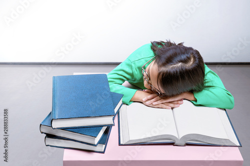 Asian Cute Girl With Glasses Fall Asleep On A Book On The Desk