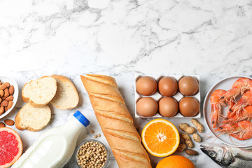 Wall Mural - Flat lay composition of different products and space for text on white marble table. Food allergy concept