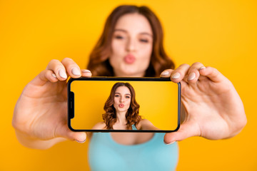 Wall Mural - Photo of lady holding telephone making selfies sending followers air kisses wear tank-top isolated yellow background