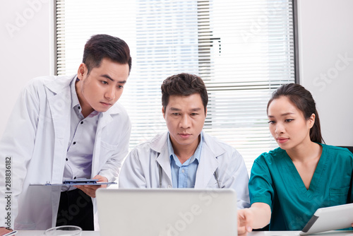 Doctor Team Working At Computer Desk In Hospital Kaufen Sie