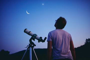 Wall Mural - astronomer with a telescope watching at the stars and moon. my astronomy work.