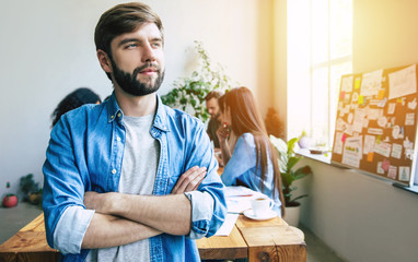 Wall Mural - Modern beautiful confident young business man in smart casual wear   stands in front of successful business team that working with graphs and documents