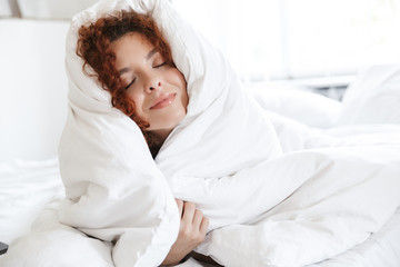 Poster - Positive optimistic young lady in lingerie indoors in home hotel lies in comfortable bed.