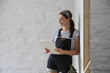 © triocean - Portrait of a young woman in overalls and protective working glasses taking a break in the middle of DIY home improvement project