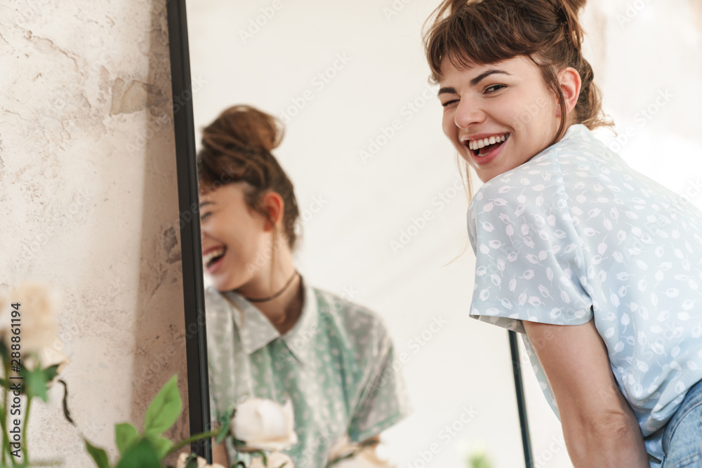 Emotional happy beautiful woman indoors at home posing near mirror looking camera. - obrazy, fototapety, plakaty 