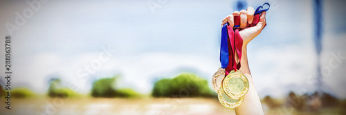 Fotomural Hand of female athlete holding gold medals