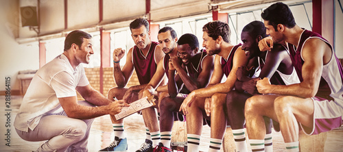 Fotografía Coach explaining game plan to basketball players