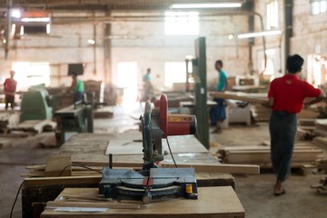 Sticker - Close shot of a wood cutting machine in a factory with a blurred background