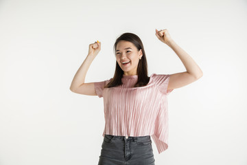 Wall Mural - Beautiful female half-length portrait isolated on white studio background. Young emotional woman in casual clothes. Human emotions, facial expression concept. Celebrating like winner, looks happy.