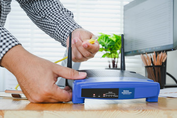 Man plugs internet cable into the router. router wireless wire broadband home concept