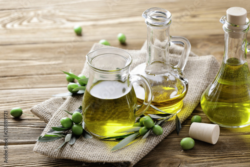 Fotografía olive oil and fresh green olives on wooden background
