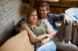 © BGStock72 - Smiling young couple relaxing and watching TV at home