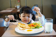 © Asada - Asian kid having a healthy breakfast in the morning.