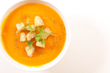 bowl of soup with crouton and parsley on white background