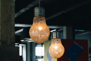 Industrial pendant lamps against wall. Loft interior. Edison bulbs. Concept interior lighting