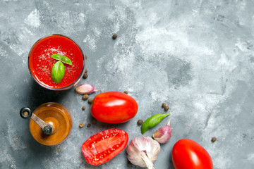 Wall Mural - Tasty tomato juice with fresh spices, garlic, pepperr and basil. Drinking glass on the table. Copy space