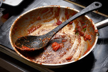 Dirty Saucepan And Spoon With Remains Of Tomato Souse, Ready To Be Washed Up
