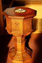 Sunbeams Streaming In On Old Traditional Eight Sided Wooden Baptismal Font With Crucifix Depicting Holy Trinity - Concept Of Baptism In The Name Of The Triune God