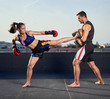 © Xalanx - Young woman kickboxer in urban environment, training