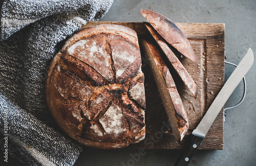 Cuadros en Lienzo Flat-lay of freshly baked sourdough bread loaf and bread slices on rustic wooden