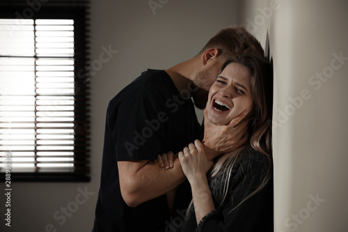 Fotografía Man choking young woman indoors. Stop sexual assault