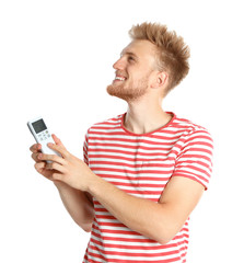 Wall Mural - Young man with air conditioner remote on white background