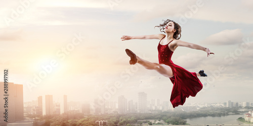 Young and beautiful female dancer in a red dress