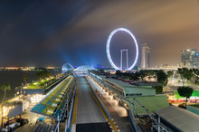 Singapore Formula One Grand Prix Circuit At Night, In Front Of The Marina Bay Area And The Singapore Flyer Wheel