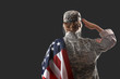 Saluting female soldier with USA flag on dark background, back view