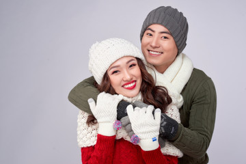 Wall Mural - Happy young lovers in knitted woolen clothing hugging and looking together.