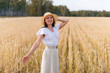 © mikhail_b_azarov - Happy woman in a flying dress and a hat on a wheat field. Freedom, joy concept.