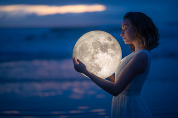 Wall Mural - tender image of a girl. female magic. beautiful attractive girl on a night beach with sand hugs the 