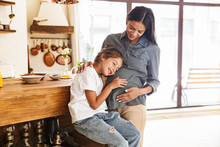 Image Of Beautiful Family Little Girl Listening To Her Pregnant Mother's Belly At Cozy Apartment