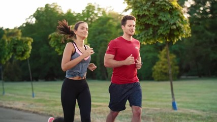 Wall Mural - Young couple jogging together in the park