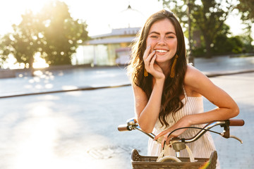 Wall Mural - Beautiful smiling girl wearing summer dress riding