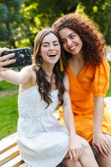 Wall Mural - Two cheerful young girls friends spending time outdoors