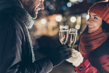 Poster - Close-up cropped portrait of his he her she nice attractive lovely charming cheerful cheery couple wearing warm outfit holding in hands glasses congratulating outdoors spending vacation