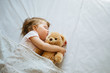 © kaloriya - Little baby sleeping on bed at home with soft toy. Free space