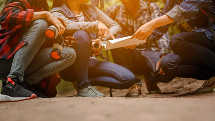 Group of young friends hiking looking at map and planning hike.