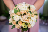 Fototapeta Kwiaty - Beautiful wedding bouquet of flowers in the hands of the bride