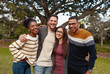 Portrait of a smiling diverse group of young friend enjoying in the park - colorful clothing - very happy 