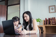 © KOTL - Beautiful asian mother and daughter working together at home office by the window. in concept of single mom or single parent.