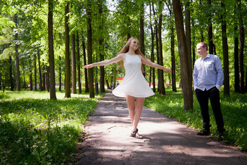 Young man and woman couple walk in the park. Spring or summer love story. Young happy family