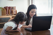 © KOTL - Beautiful asian mother and daughter working together at home office by the window. in concept of single mom or single parent.