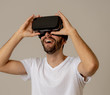 © SB Arts Media - Portrait of excited and amazed young man wearing Virtual Reality headset exploring 3D world