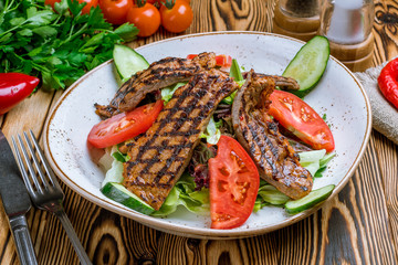Wall Mural - Steak salad with beef and vegetables on wooden table