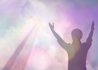 Wall Mural - soft focus and Silhouettes of man raise hand up worship God over the cross in cloudy sky . Christian background with copy space for your text