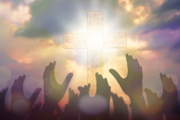 Blurred of Christian Congregation hands Worship God together in front of wooden cross in cloudy sky, conceptual image of praise and worship