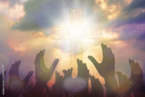 Blurred of Christian Congregation hands Worship God together in front of wooden cross in cloudy sky, conceptual image of praise and worship